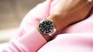 Person wearing a watch with a pink sleeve