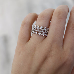 Three stacked leaf-motif diamond bands on a hand's ring finger.