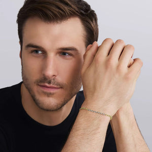 a man wearing a black shirt holding his hands wearing a two tone bracelet on a white background