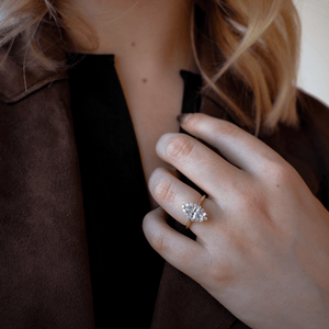 Close-up of .33ctw Marquise Cut Diamond Halo ring on woman's finger showing marquise center diamond, halo and 14K gold band