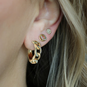 Close up of ear wearing 14K yellow gold Love Knot earring on earlobe showing interlocking circles with 0.09 ctw diamonds