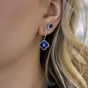 Close-up of Sapphire & Diamond earrings on ear showing clover drop of blue sapphires with diamond halo in white gold
