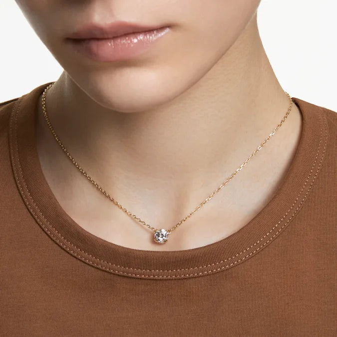 Front view of Constella pendant showcasing round zirconia center stone and pave sides on gold-tone plated chain on model