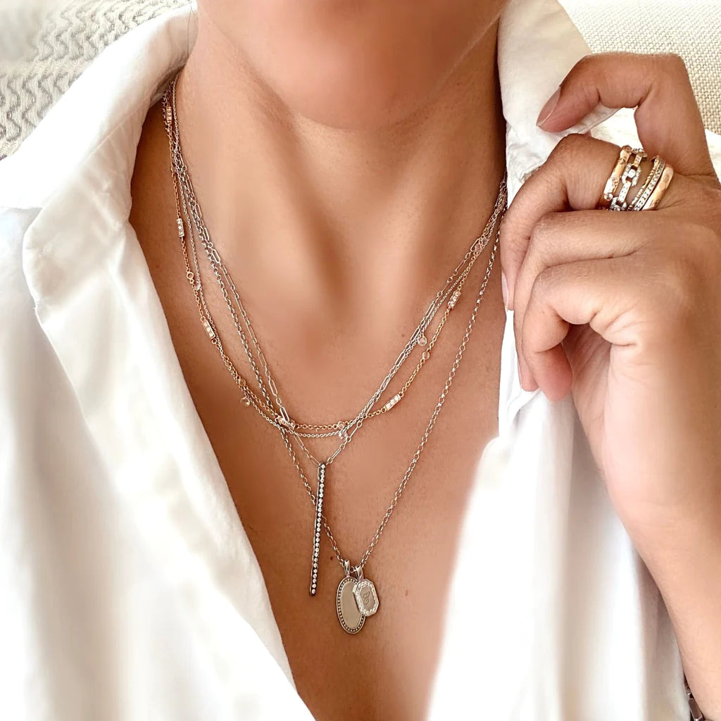 Close-up of Barrel Diamond Chain on model’s neck showcasing mini barrel links set with brilliant-cut diamonds, layered over a white blouse