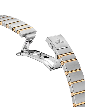 Close-up of OMEGA Constellation 28 mm bracelet showing two-tone stainless steel and Sedna gold butterfly clasp