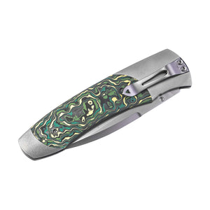 Closed folding pocket knife with green-and-yellow mokume-pattern handle and stainless clip