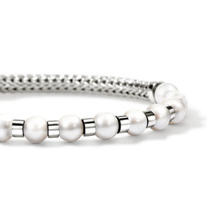 close up of pearls and silver bracelet on a white background