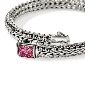 A silver braided chain bracelet with a rectangular clasp adorned with small red gemstones, shown on a clean white background.