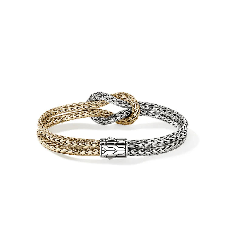 Top view of 14K yellow gold and sterling silver love knot bracelet with braided two-tone bands and polished clasp on white