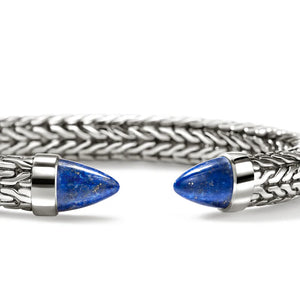 A silver-toned braided cuff bracelet with two pointed blue lapis lazuli stone end caps, shown on a clean white background.