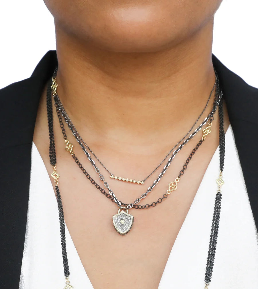 Close-up of Protection Shield Necklace on model showing shield pendant with champagne diamonds and mixed metal chains