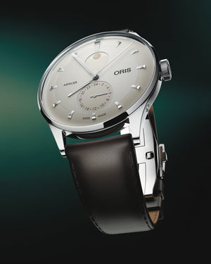 Oris watch with black leather strap on a gradient background