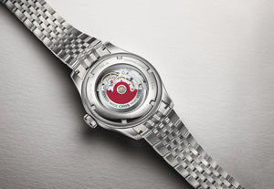 Caseback of a silver watch with on a gray background