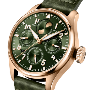Angled close-up of IWC Big Pilot's Perpetual Calendar watch showing green dial, gold case, calendar subdials on white