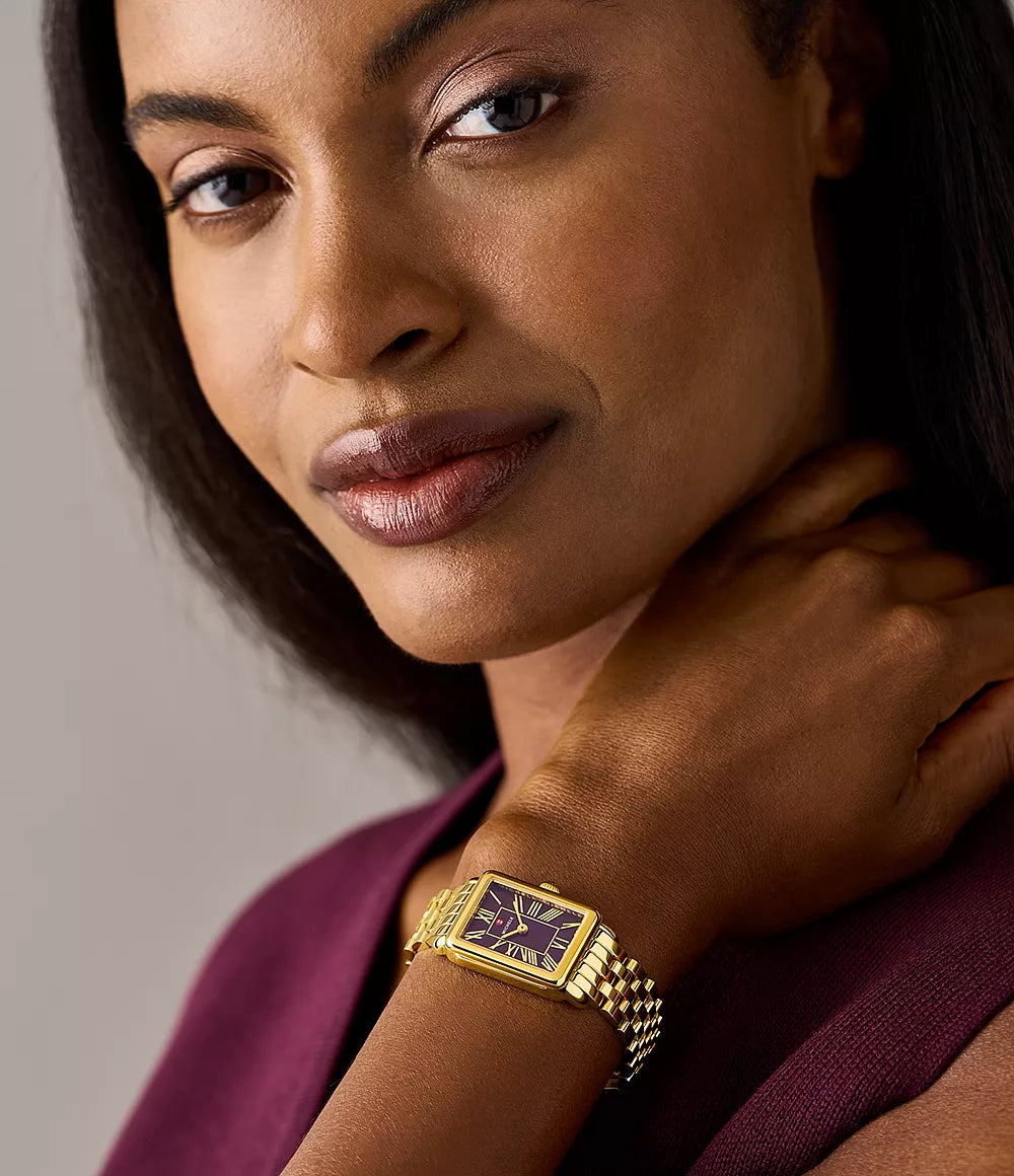 Woman wearing 18K gold‑plated rectangular watch with purple dial and Roman numerals