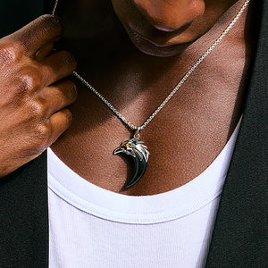 Person wearing a necklace with a unique pendant, close-up of the necklace and skin.
