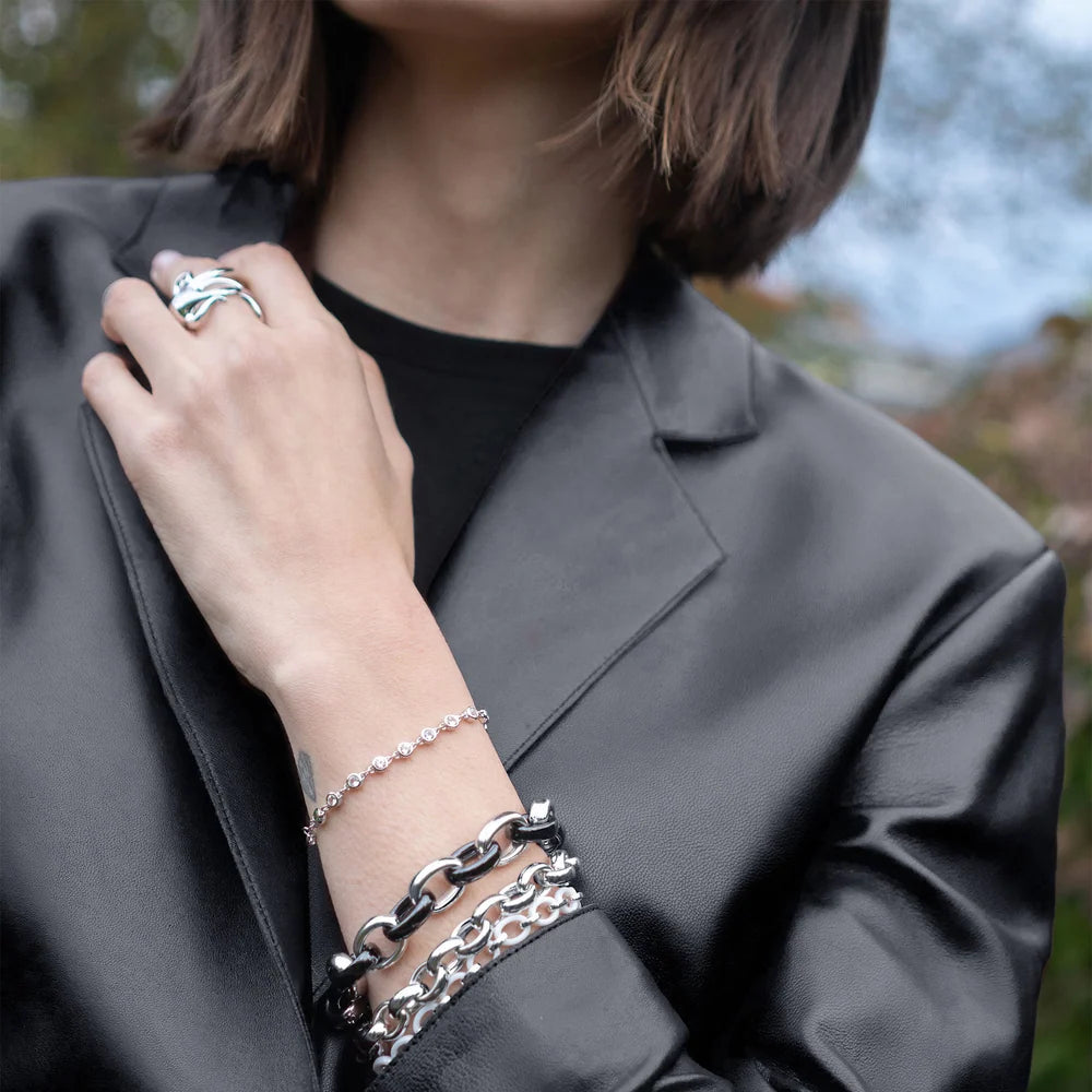 close up of a woman in a black leather jacket wearing multiple silver bracelets