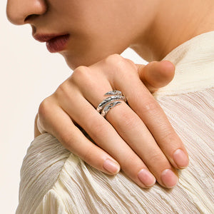 Close-up of a hand wearing two rings with a neutral background