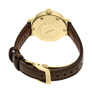 Rear view of Seiko Presage Cocktail Time watch showing gold-tone case back with Seiko engraving and dark brown leather strap on white background