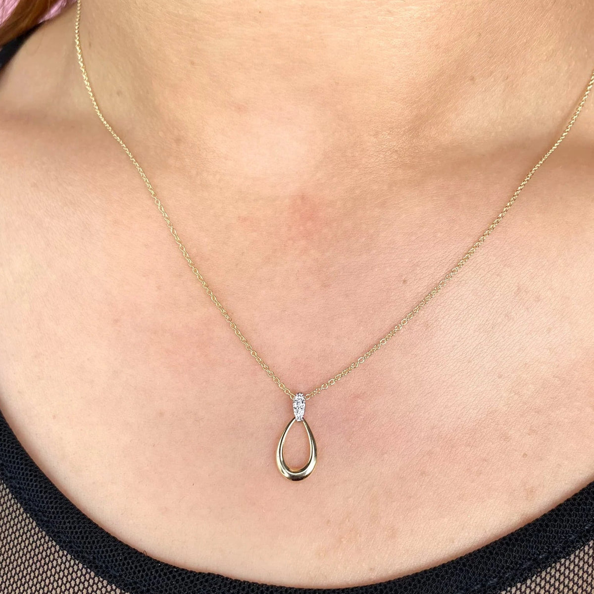 Close-up front view of 0.03ctw Diamond Necklace showing two-tone 14K teardrop pendant and diamond bale on bare neck