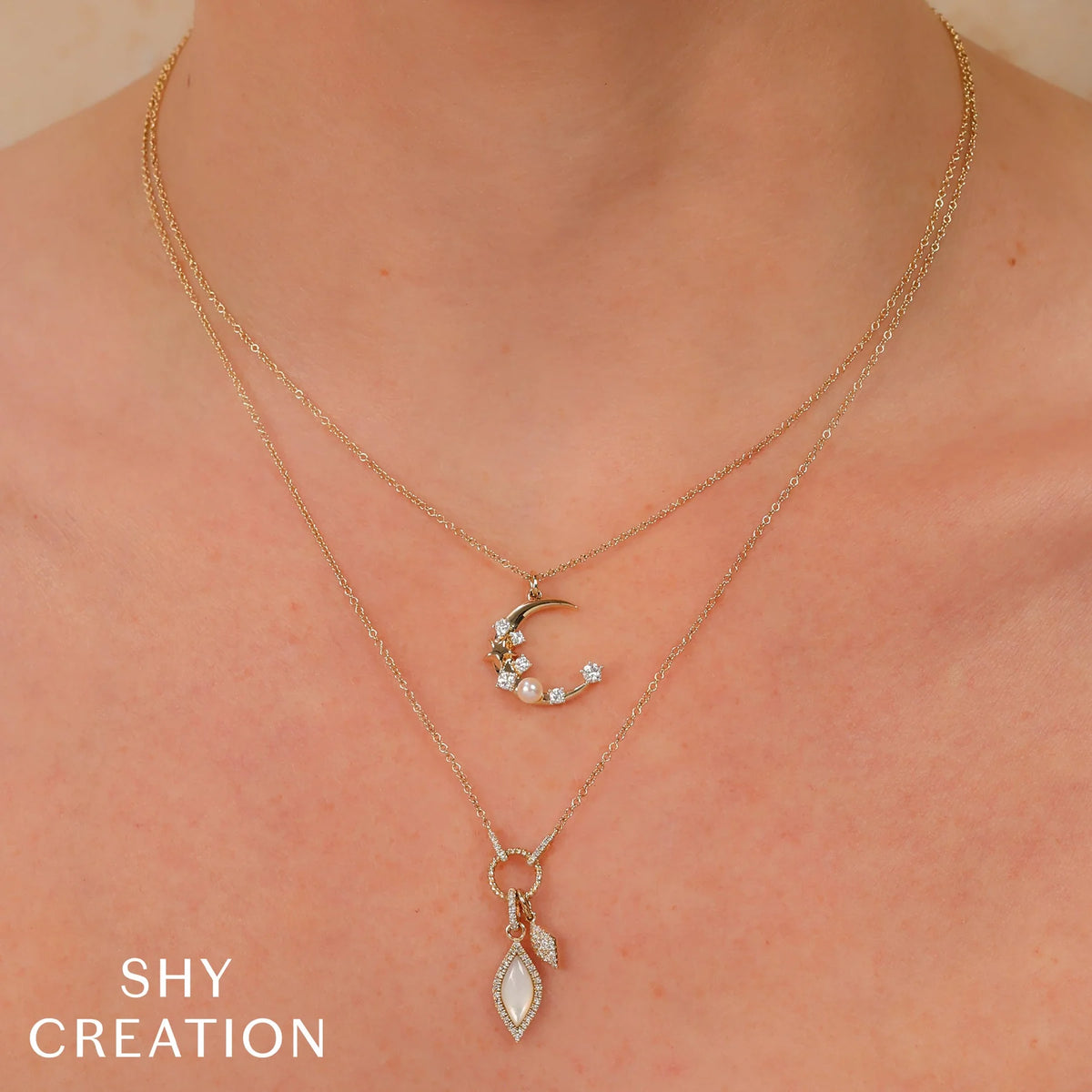 Close-up front view of 14K white gold crescent moon pendant with 0.30 ct diamonds and cultured pearl on bare neck