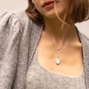 upclose image of a woman wearing a light brown sweater and silver necklaces