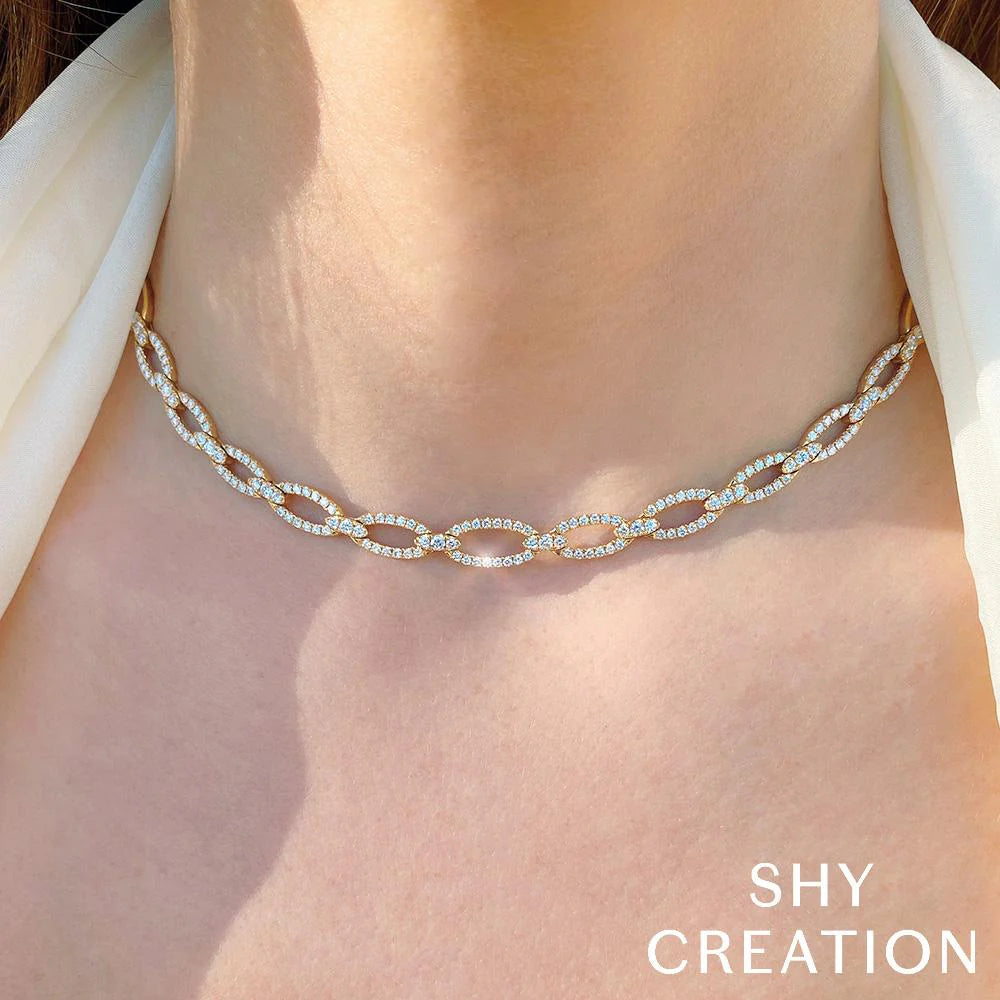 Front view of 16 inch diamond link necklace in 14K white gold with pavé diamonds on oval links worn against white blouse
