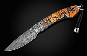 Decorative knife with intricate blade design and wooden handle on a dark background