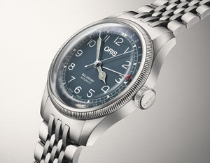 Silver Oris watch with blue dial on a light gray background