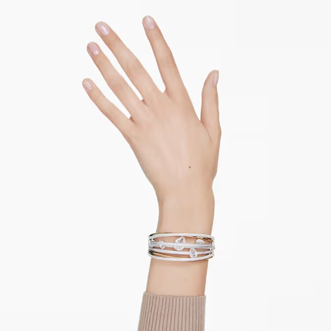 Wrist view of Hyperbola bangle showcasing twisted multiple bands in rhodium and gold-tone plating with clear crystals on a mannequin hand
