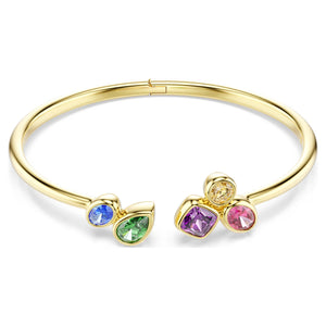Gold tone bangle with multicolored stones with different cuts on a white background.