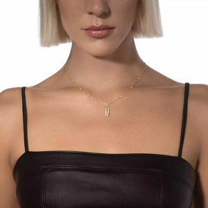 Woman wearing a gold necklace with a rectangular pendant on a white background