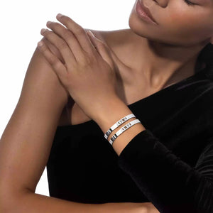 woman wearing a black dress and white gold bangle bracelets