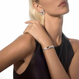 Woman wearing silver earrings and bracelet on a white background