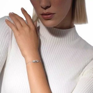 Close-up of a person wearing a silver bracelet on a white background