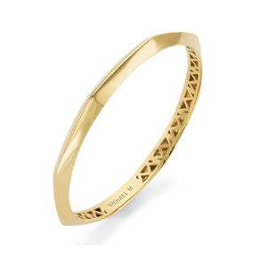 Angled view of Octave bangle showcasing faceted edges, octagon shape and interior lattice in yellow gold on white