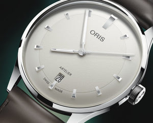 Oris watch with a white dial and brown leather strap on a dark background