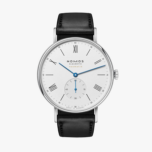 Nomos watch with black leather strap and white dial on a white background