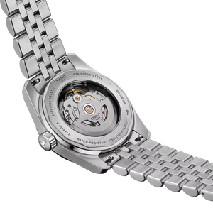Close-up of a silver watch with a visible mechanical movement on a white background