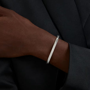 up close of a woman wearing a silver and crystal curved bangle bracelet on a white background