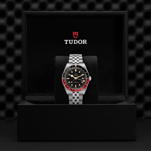 Tudor watch in a black display case with a textured black background