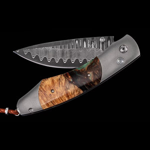 William Henry Fire & Ice folding knife with Damascus-pattern blade and burl wood handle on black.