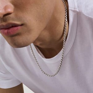 Close-up of model wearing 24-inch sterling silver box chain necklace, 4.8 mm, resting on a white t-shirt