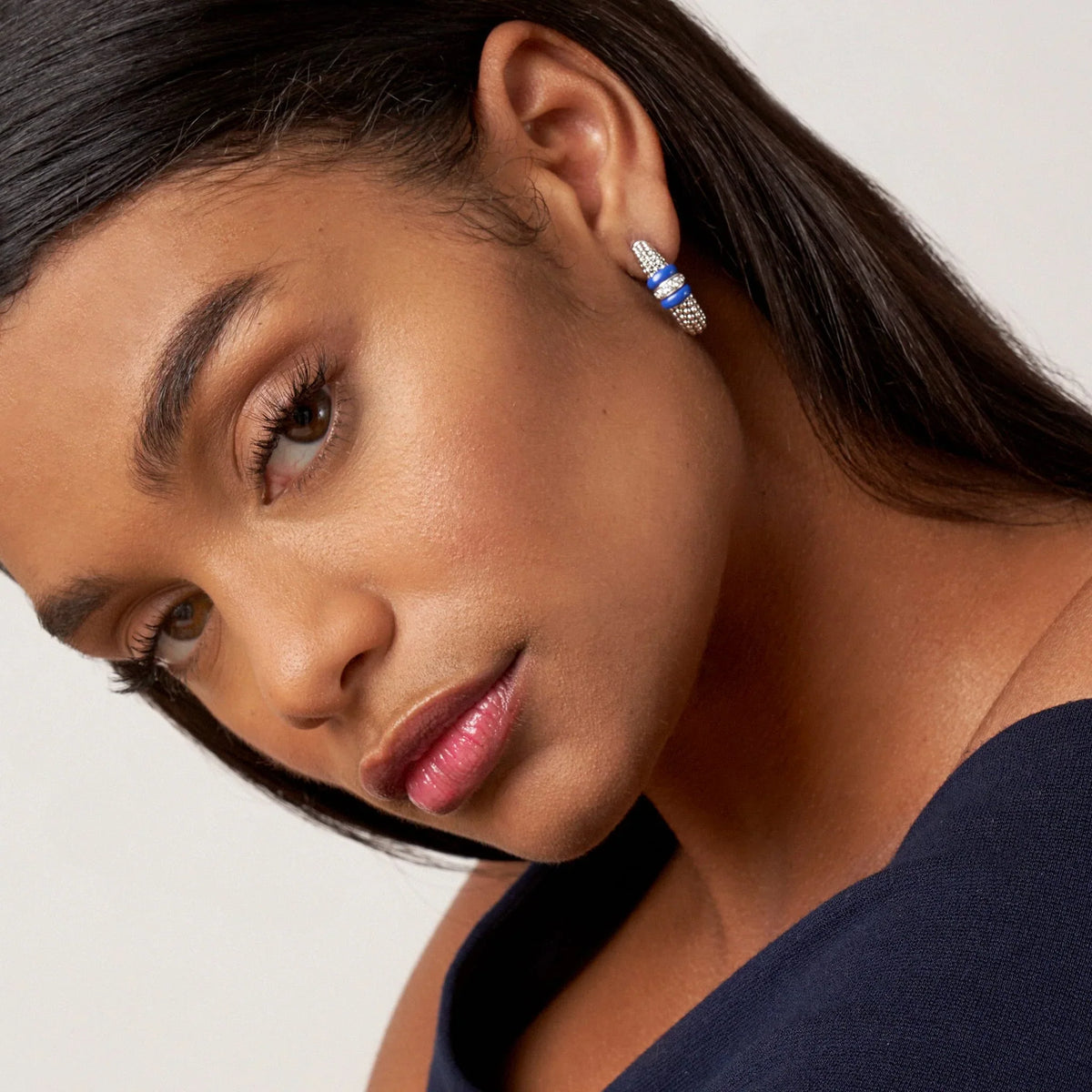 Close-up of Ceramic Caviar hoop on model’s ear showing ultramarine ceramic bands, beaded sterling silver and 0.21ctw diamonds