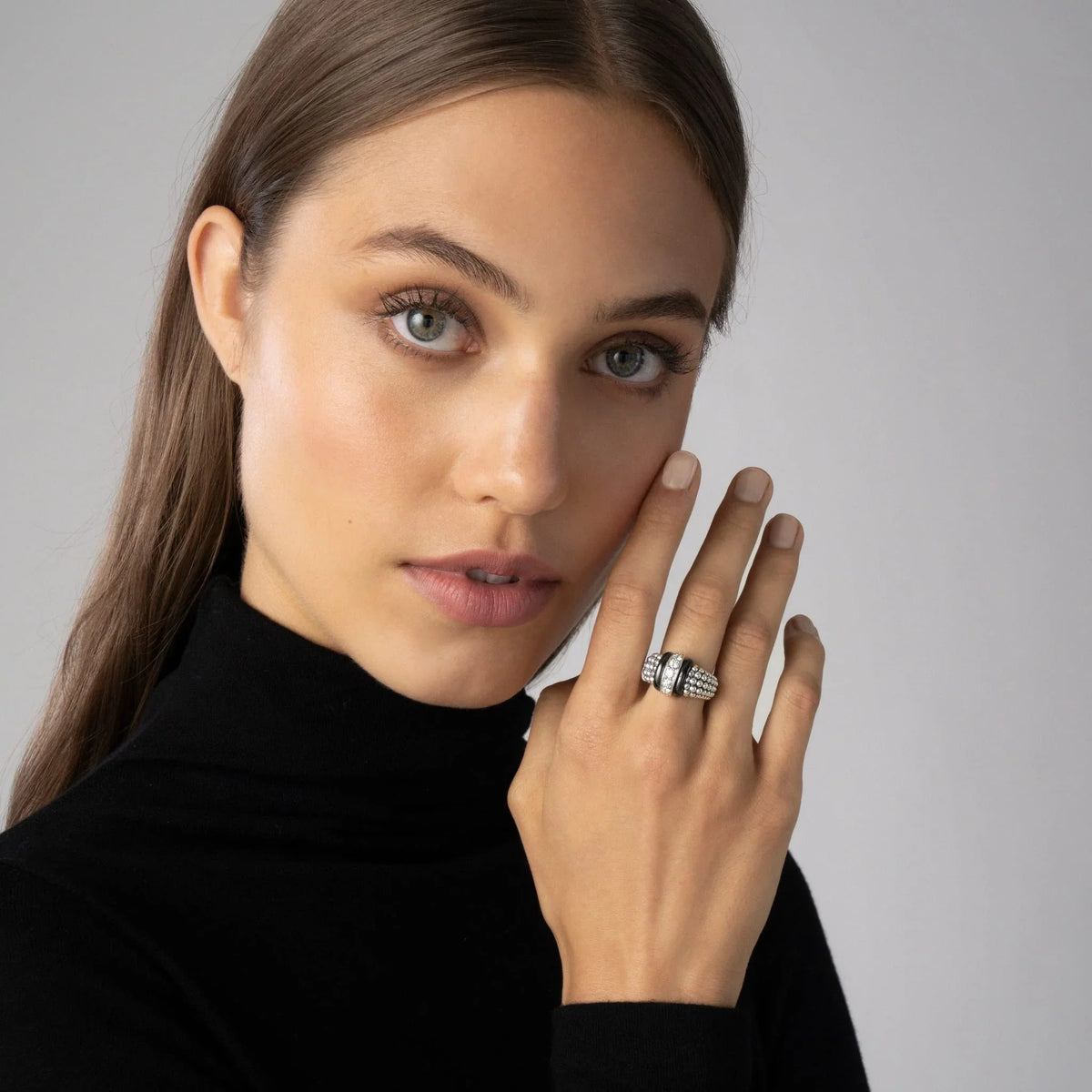 Close-up of model’s hand wearing Ceramic Caviar diamond ring showing black ceramic band with diamond stations and beaded silver bands