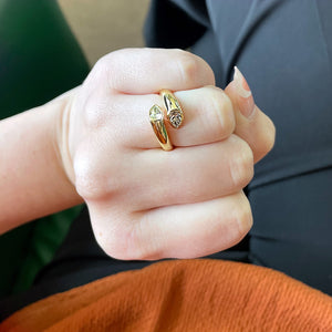 Close-up of Gold Toi et Moi diamond ring on finger showcasing two pear-shaped diamonds in 18K yellow gold