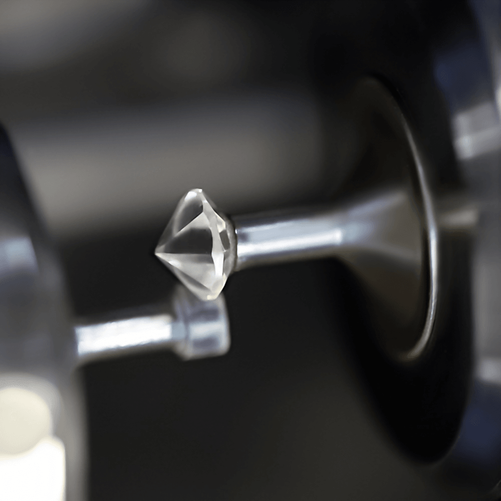 Close-up of a diamond held in a metal cutting spindle during faceting.