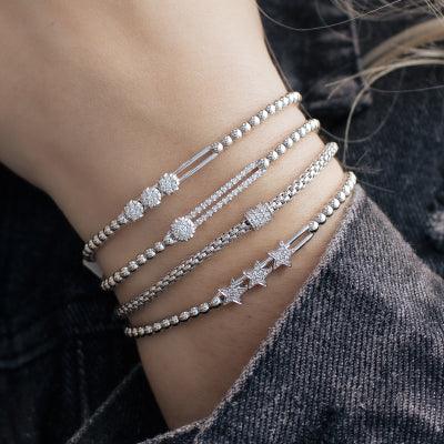 Hulchi Belluni five silver beaded bracelets with diamond and star accents stacked on a wrist