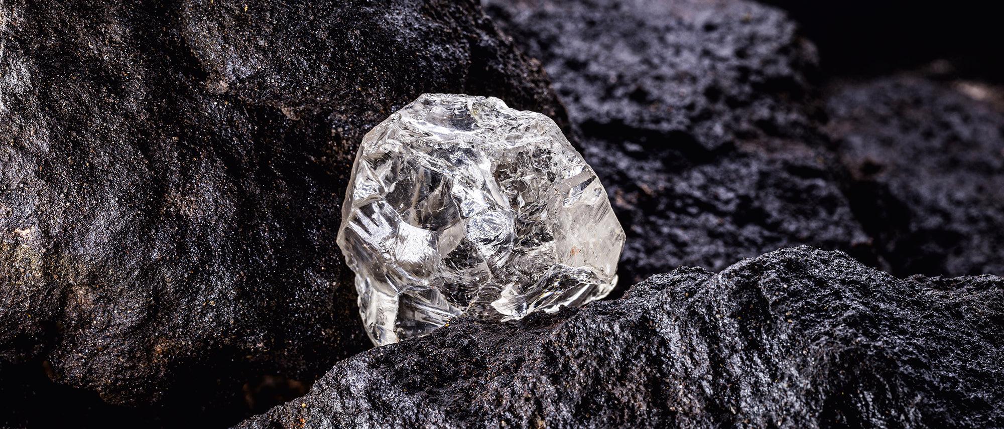 Rough Cullinan diamond crystal resting on dark host rock