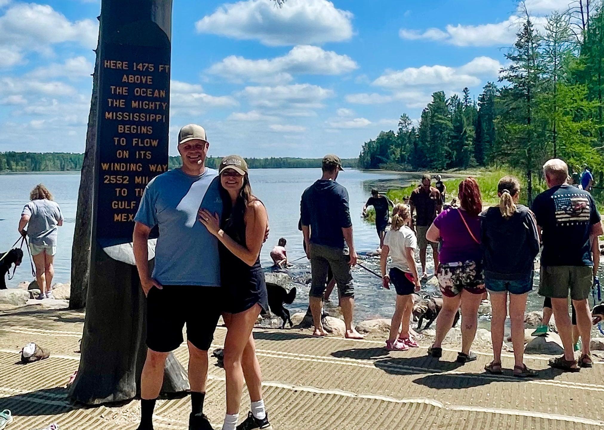 Jenna & John posing for a photo standing near a memorial place. 